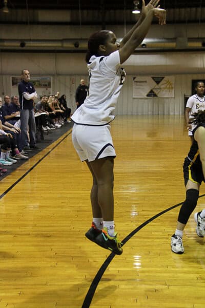 volleyball players standing at the net with hands up